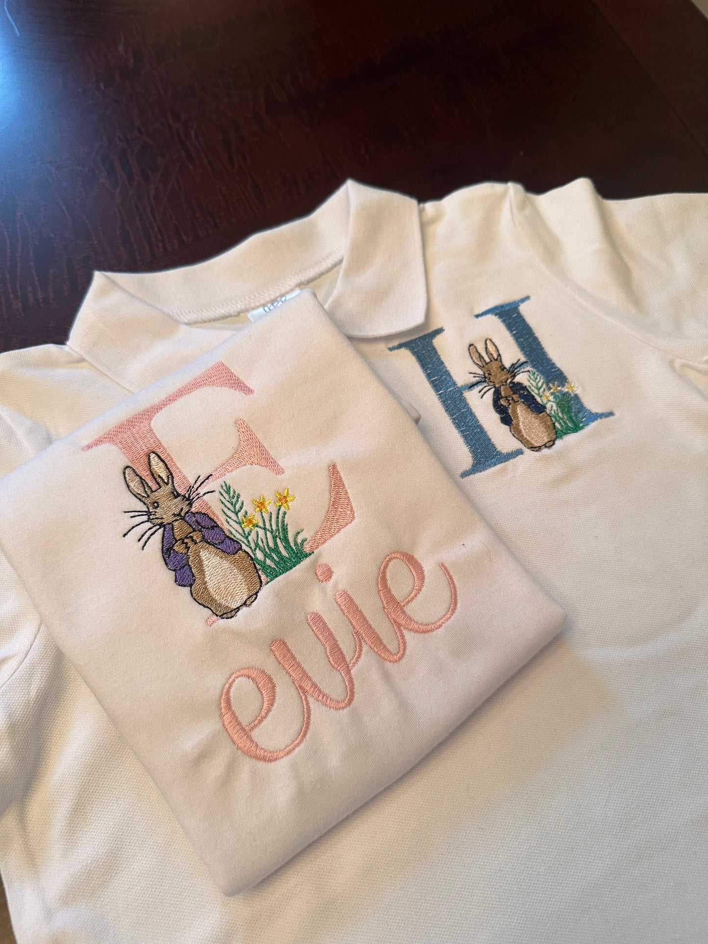 Set of personalized Easter shirts for kids featuring embroidered Peter Rabbit design with custom initials and names β girls shirt with pink 'E' and name 'Evie', boys polo with blue 'H', perfect for Easter outfits and spring celebrations.