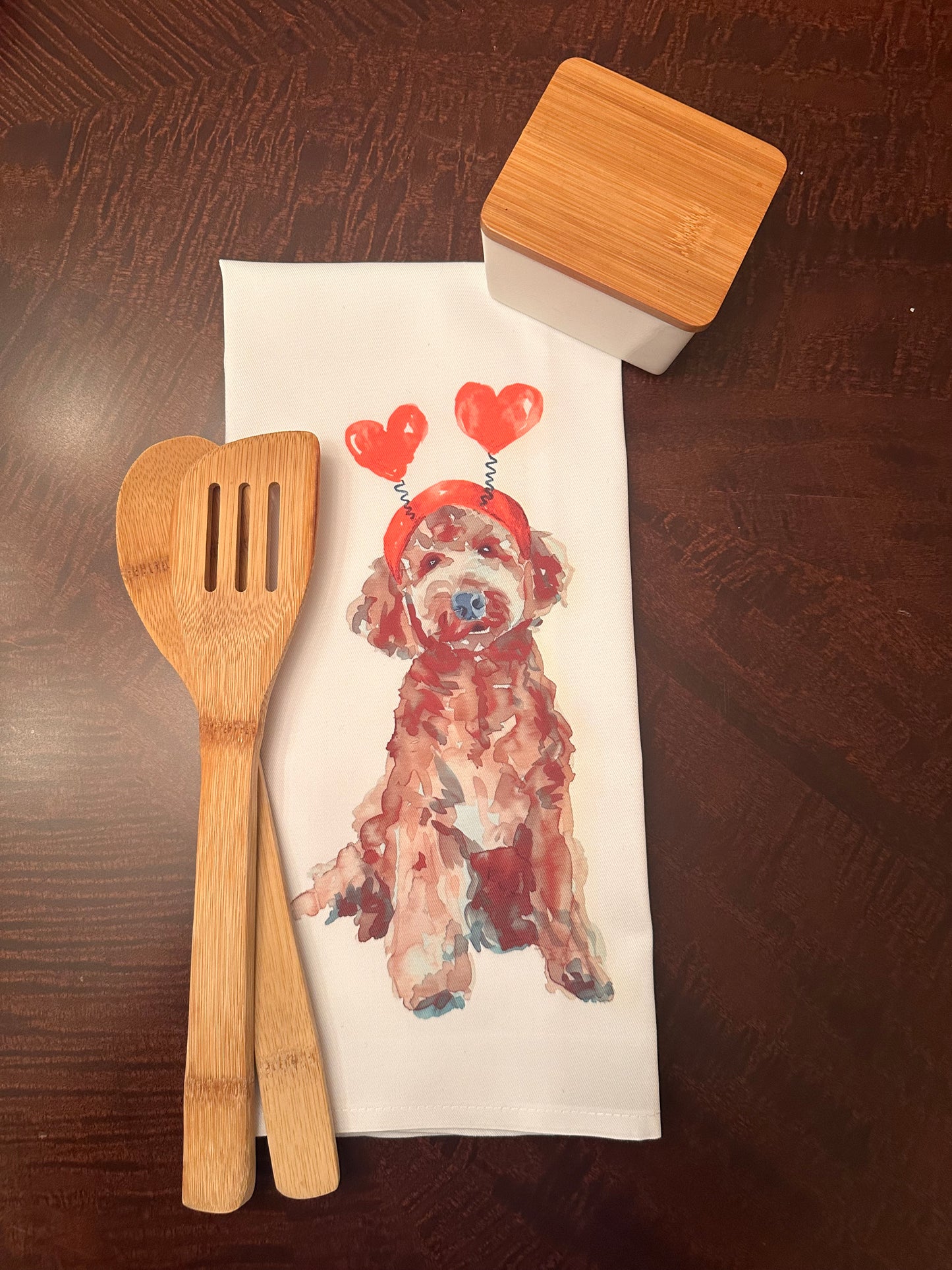 Watercolor illustration of a brown chocolate goldendoodle dog wearing a red heart headband with the playful Valentine’s Day-themed text 'Bone Appétit, Valentine,' perfect for festive pet-inspired decor or gifts.