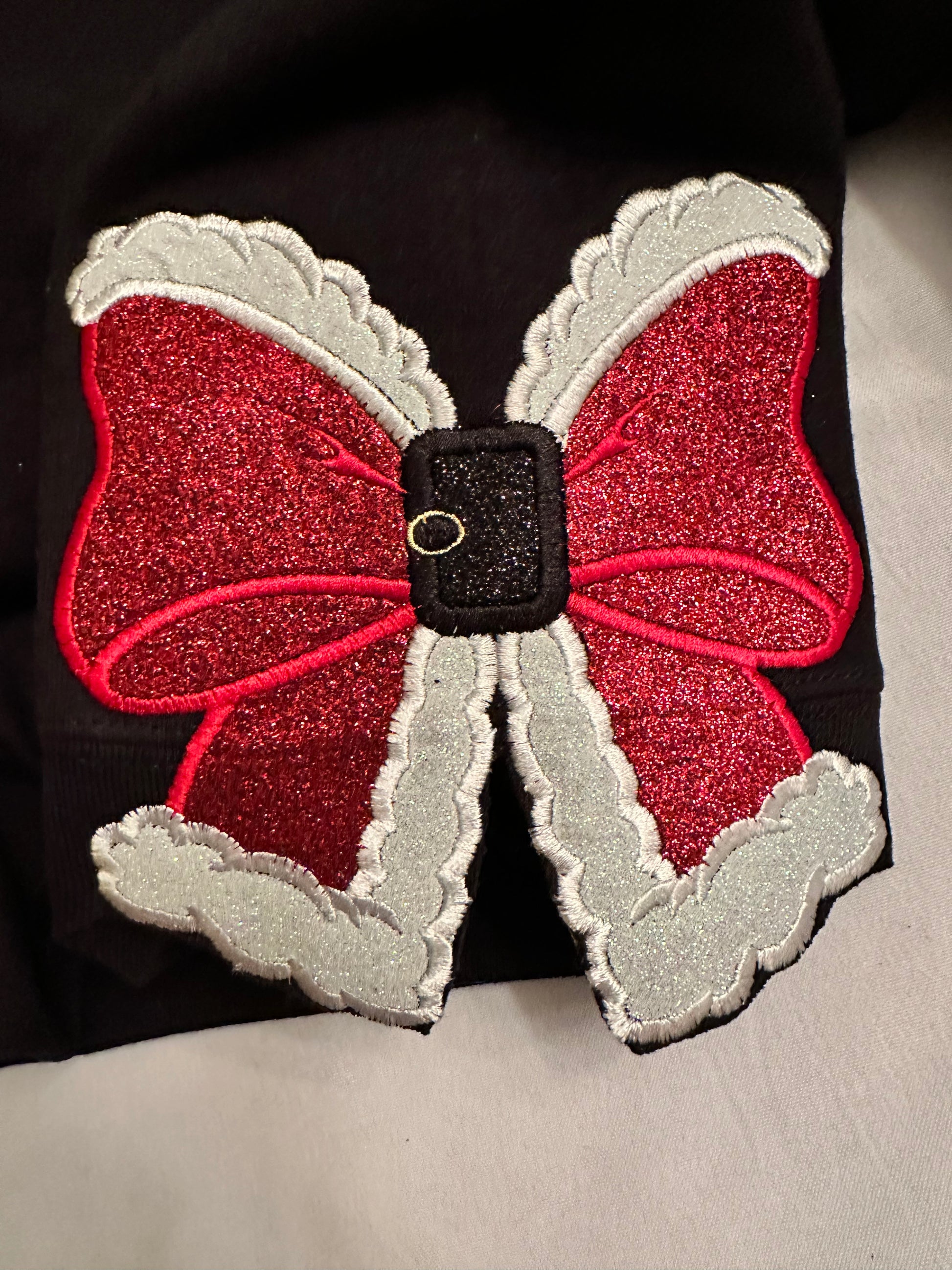Glittery red and white santa bow on black sweatshirt 