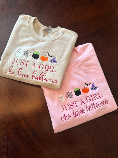 Two folded shirts with Halloween-themed text and graphics on a wooden surface