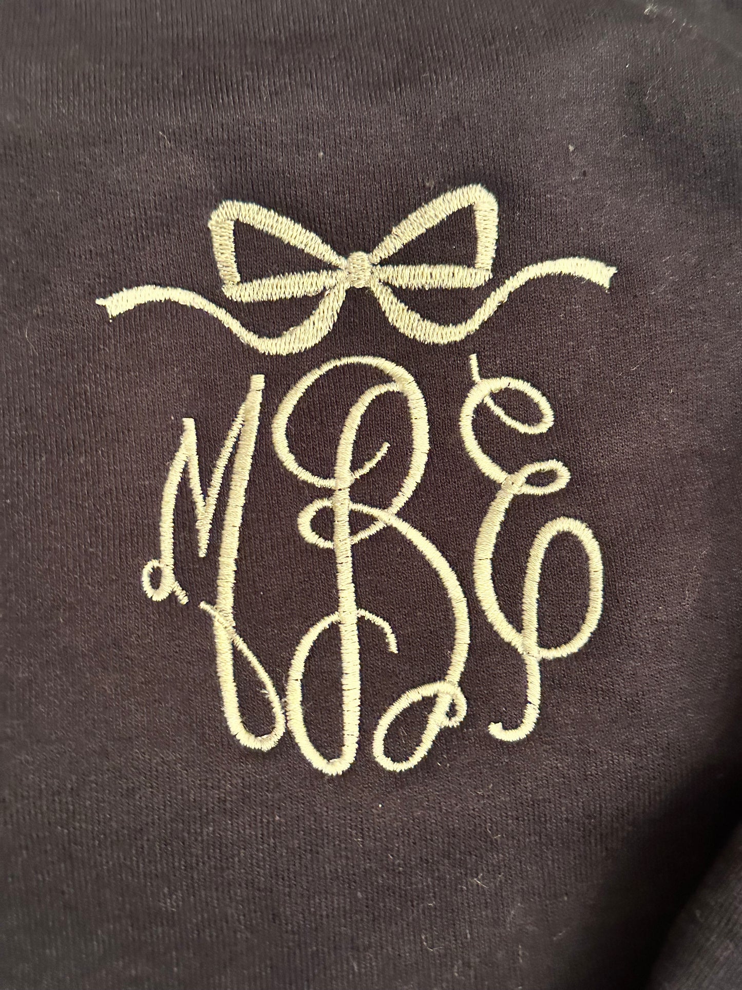 Monogram with bow frame in white thread on navy sweatshirt