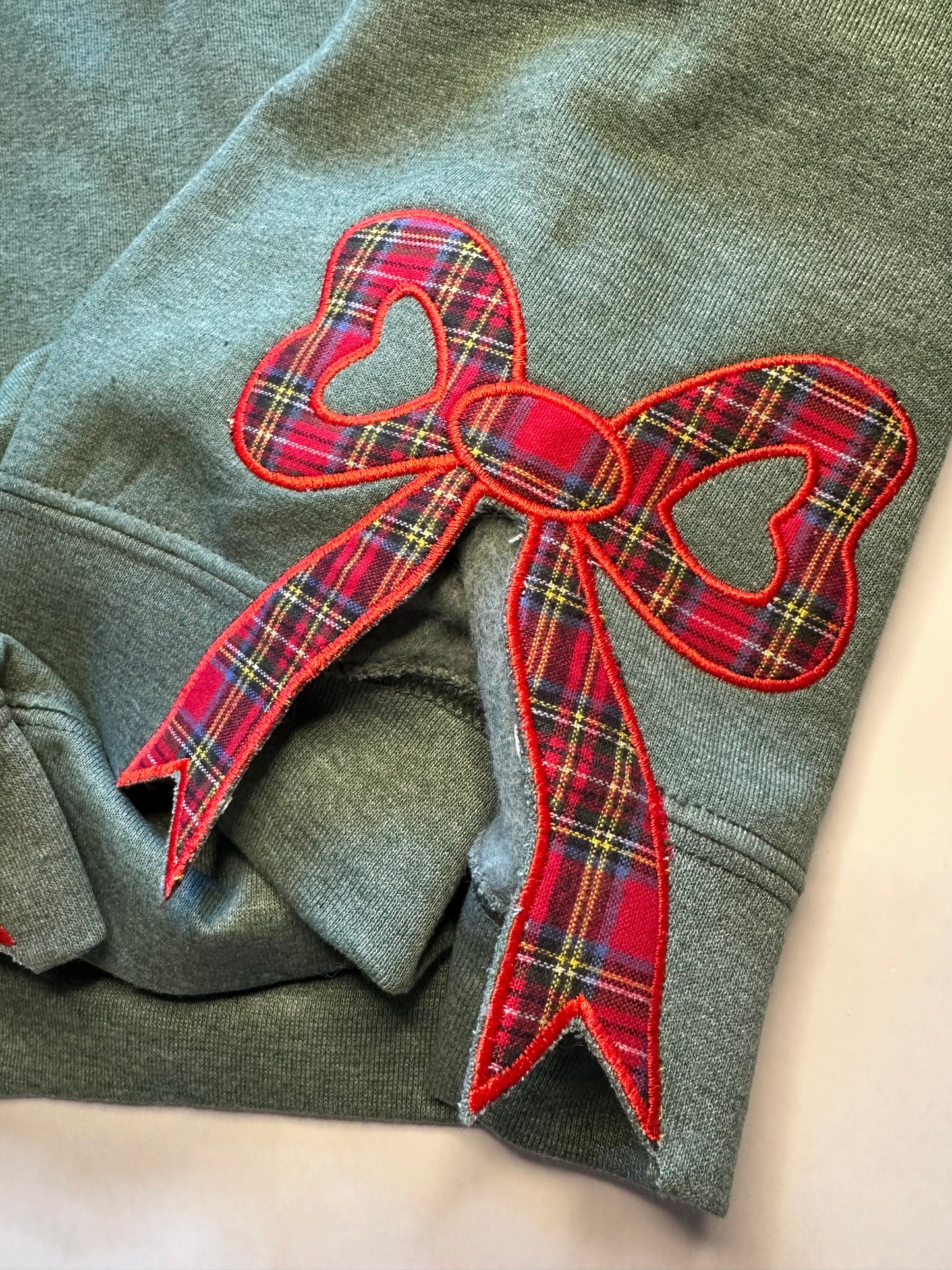 Tartan plaid side bow detail on green sweatshirt
