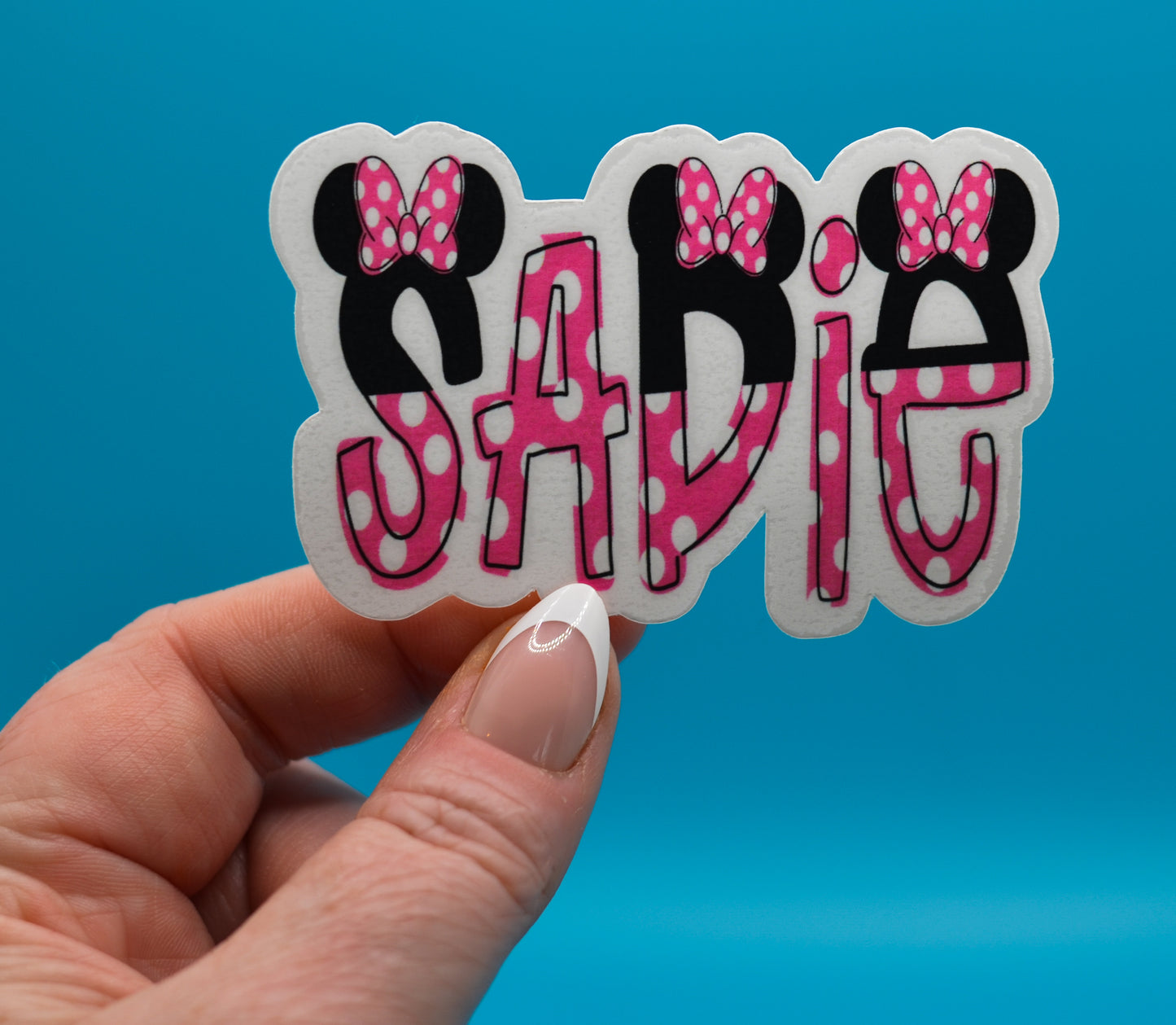 Close-up of personalized Disney stickers showing name in pink and white minnie theme.